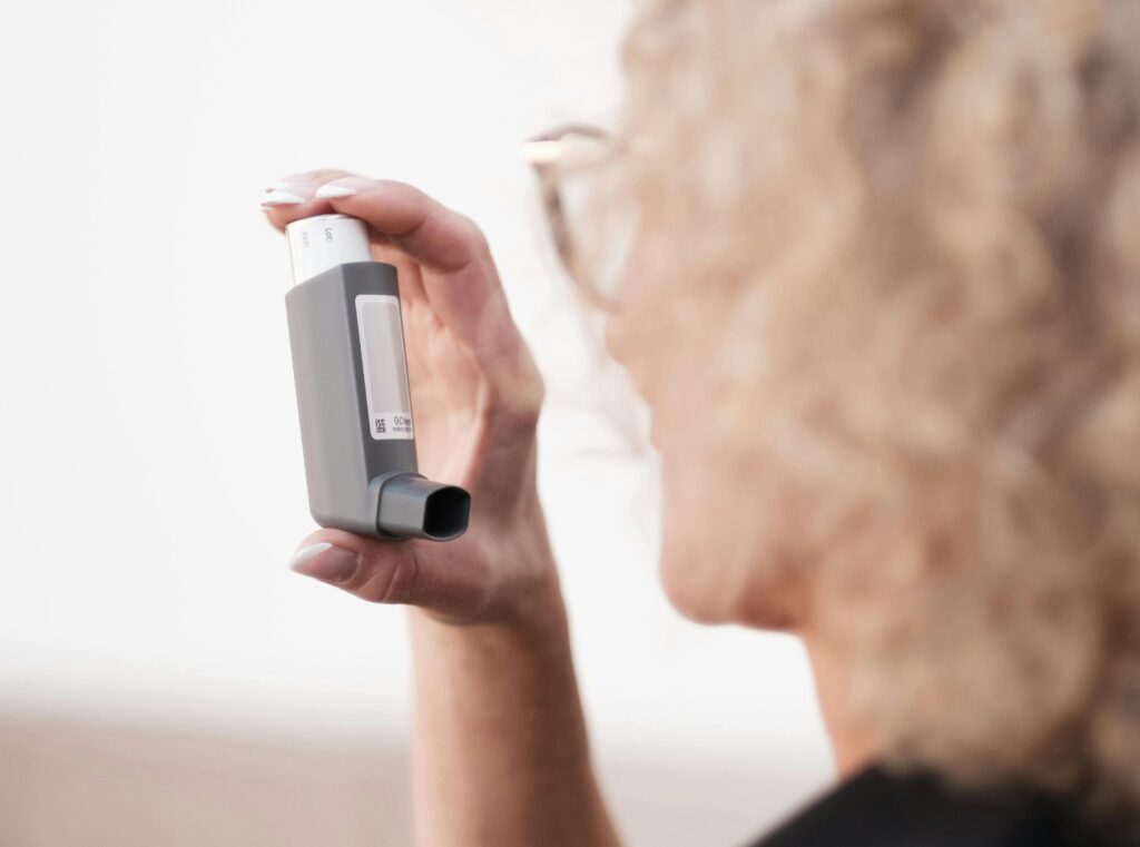 A person holding an inhaler, highlighting asthma management and relief methods.
