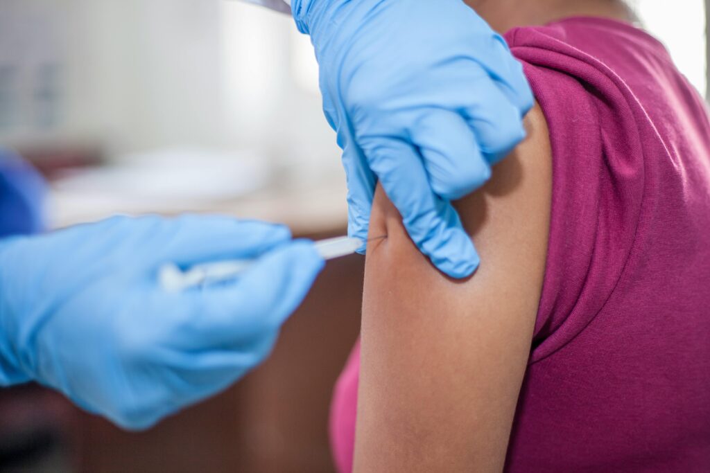Close-up of a healthcare professional administering a vaccine to an adult.